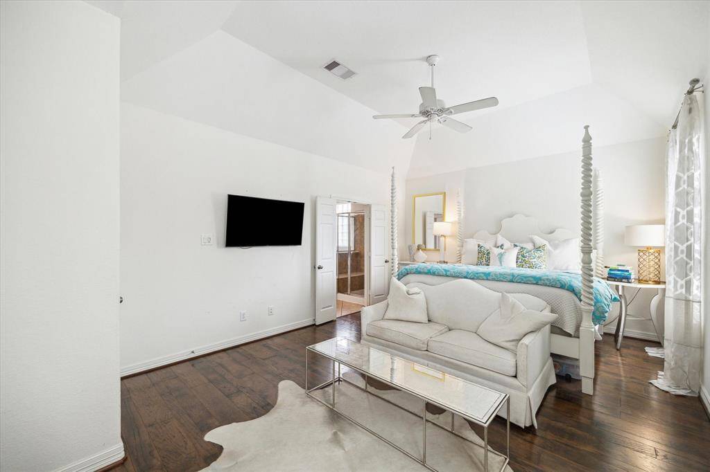 The private primary suite is located in the rear left corner of the home, away from the other bedrooms. It boasts a walk-in closet and a charming sitting area framed by corner windows with peaceful views of the backyard.