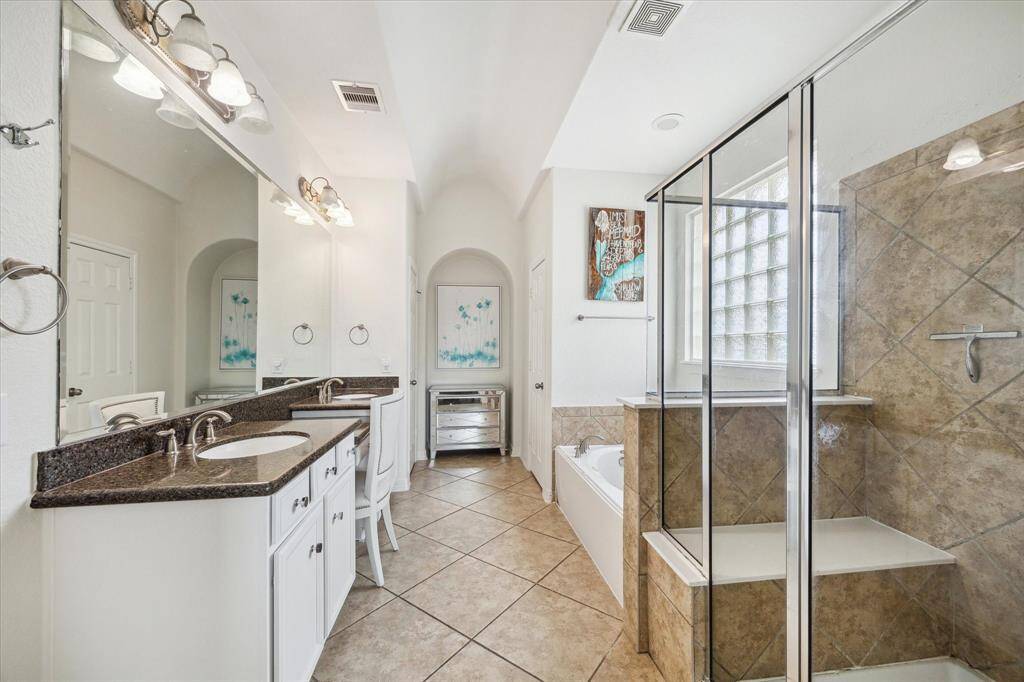 The primary bathroom offers double sinks, a vanity, and additional storage in the linen closet.