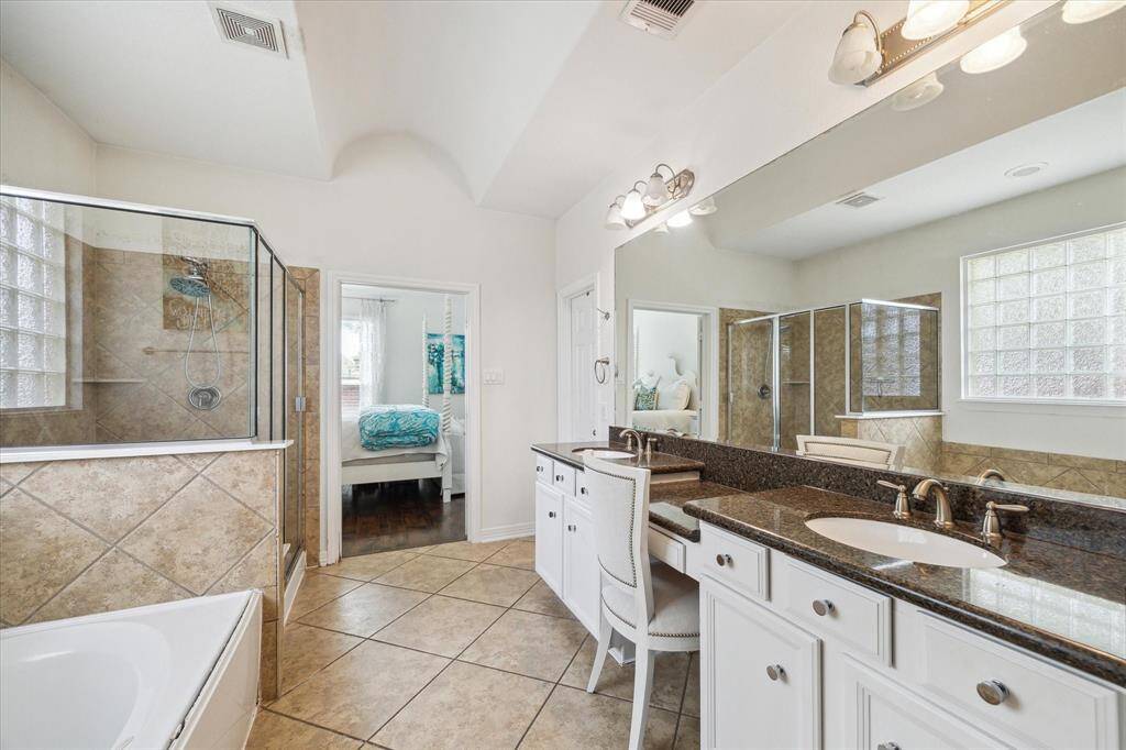The primary bathroom offers double sinks, a vanity, and additional storage in the linen closet.