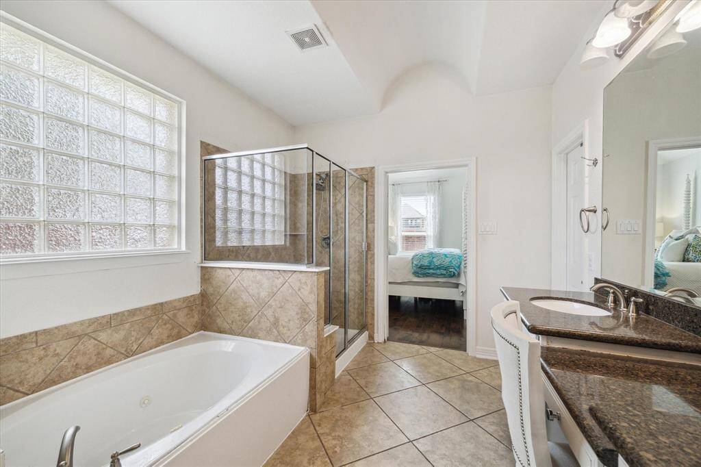 The primary bathroom offers double sinks, a vanity, and additional storage in the linen closet.