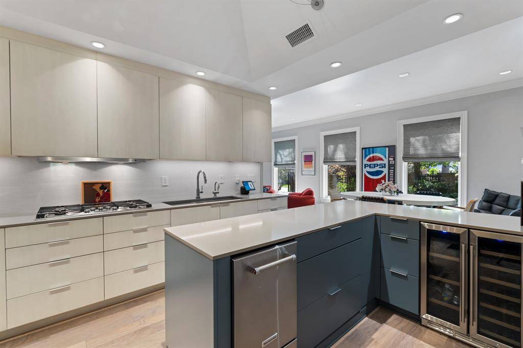The Kitchen bar area is enhanced with a wine refrigerator, ice maker, and built-in storage. It is ideal for entertaining and casual gatherings. The Kitchen, Breakfast Room and Family Room are open, highlighting a casual lifestyle.