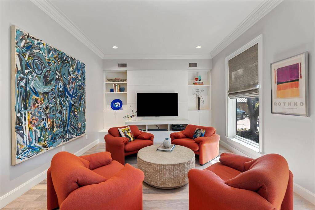 A view of the Family Room featuring crown molding, hardwood floor, and built-in shelves for collectibles.