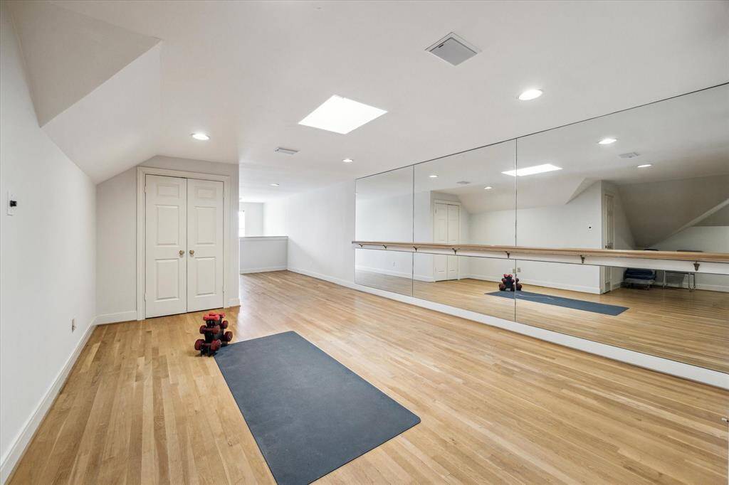 Open studio space on the third floor with hardwood flooring, mirrored wall, ballet barre, and skylight. There is a large closet on the third floor with racks for large canvases.