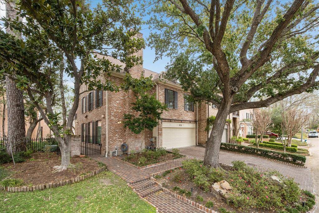 The exterior view of the home highlighting its brick façade and mature landscaping.