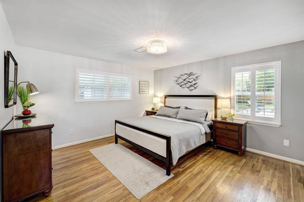 Large primary bedroom with refinished original hardwood floors and walk-in closet