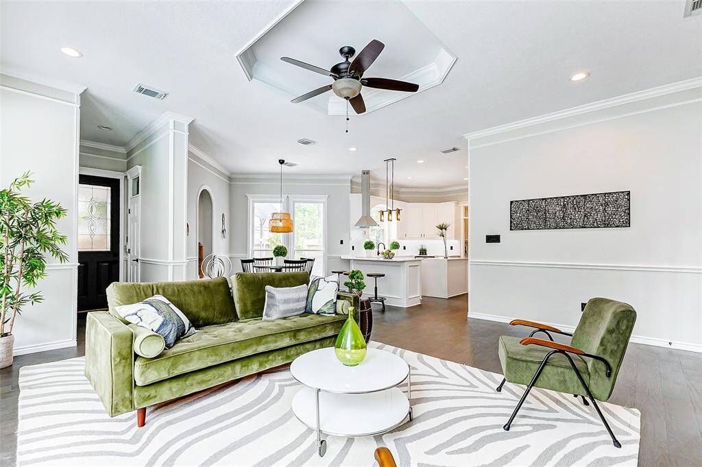 The space opens to the kitchen, breakfast area and the side entrance. Large windows and light walls create a bright, inviting atmosphere.