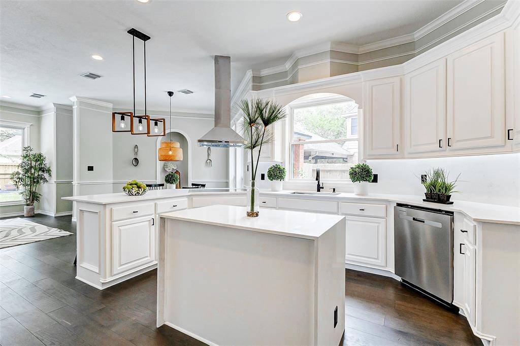 The stylish pendant lighting adds a contemporary look to this masterpiece kitchen. The open layout is complemented by a large window, offering plenty of natural light.