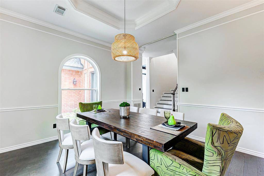 The arched windows, wainscoting, and dark engineered wood floors create a cozy yet modern atmosphere.