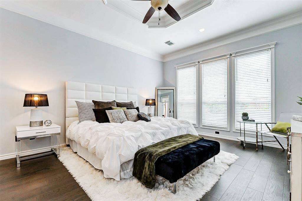 The primary bedroom with large windows is located on the first floor and overlooks the backyard and pool.