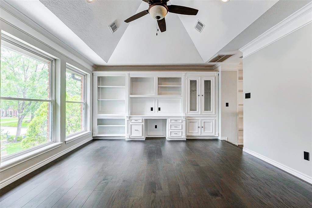 On the 2nd floor, off the stairway it is located a bright multi-functional room (game room) with large windows, dark engineered wood floors, a vaulted ceiling, and a built-in white shelving unit with a desk. Ideal for an office, study space or simply for entertainment.