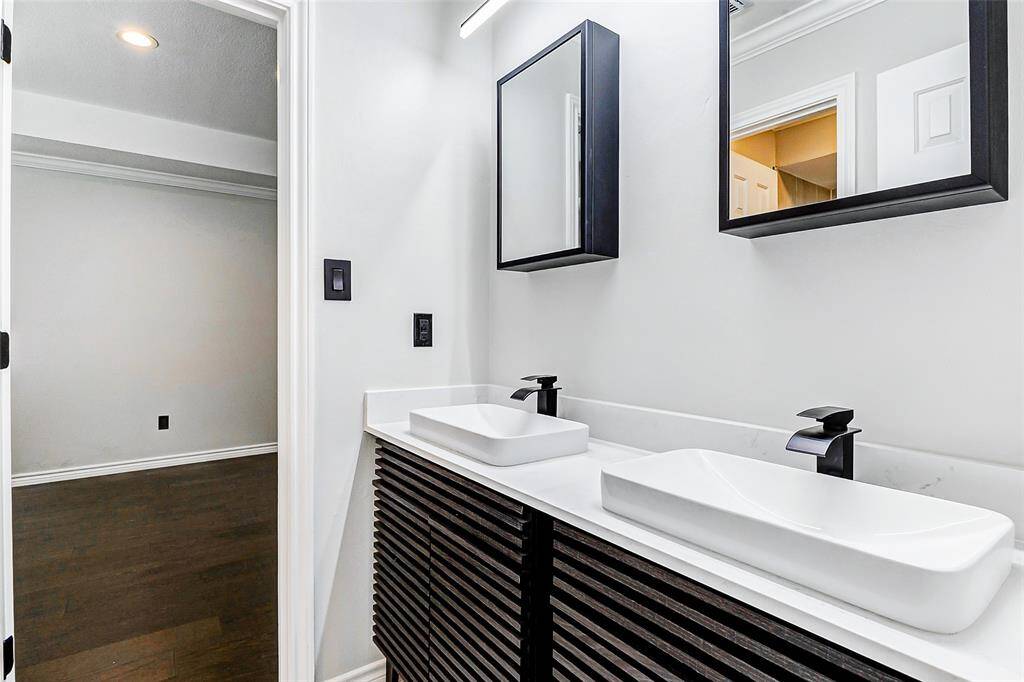 The modern Jack & Jill bathroom showcases a double black vanity with Carrara quartz countertops, elegant black fixtures and a contemporary design.