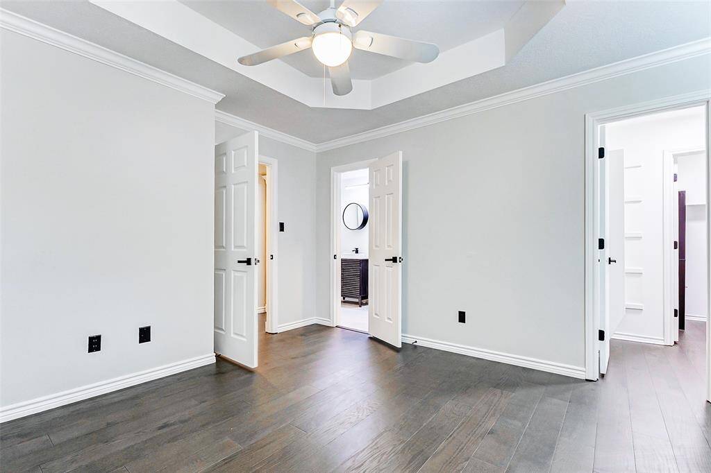 The 3rd of the secondary bedrooms features an en-suite bathroom, clean light walls, dark engineered wood flooring, and a large walk-in closet.
