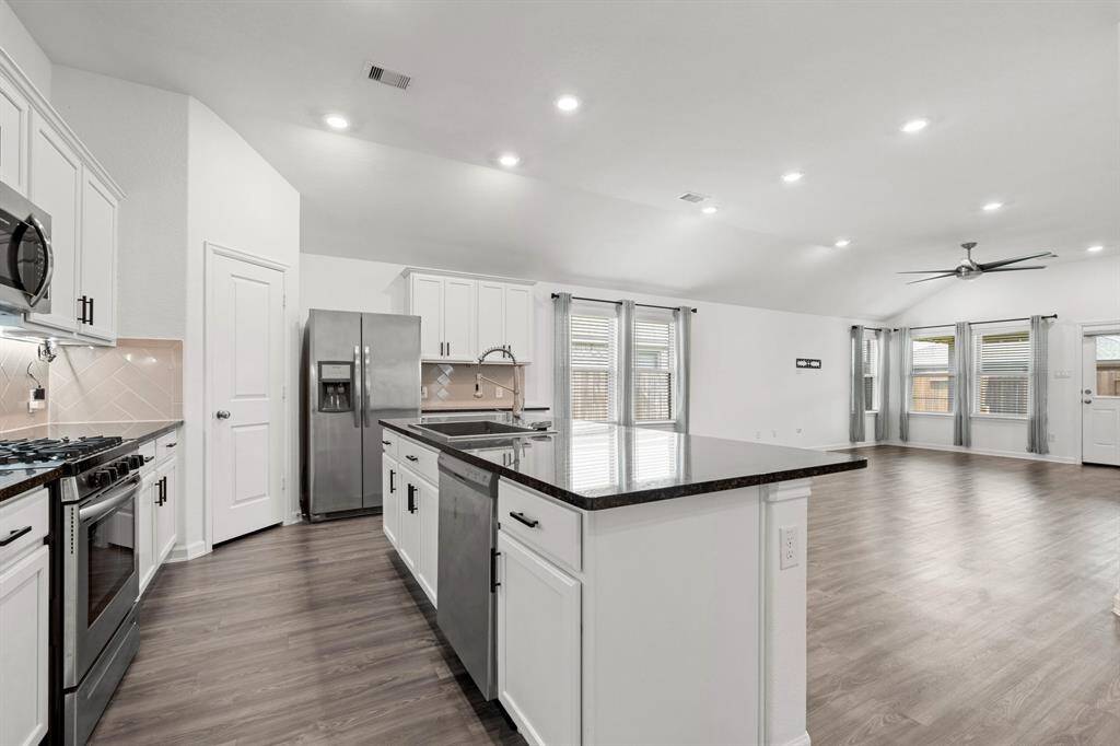 Kitchen with view towards dining and living spaces.