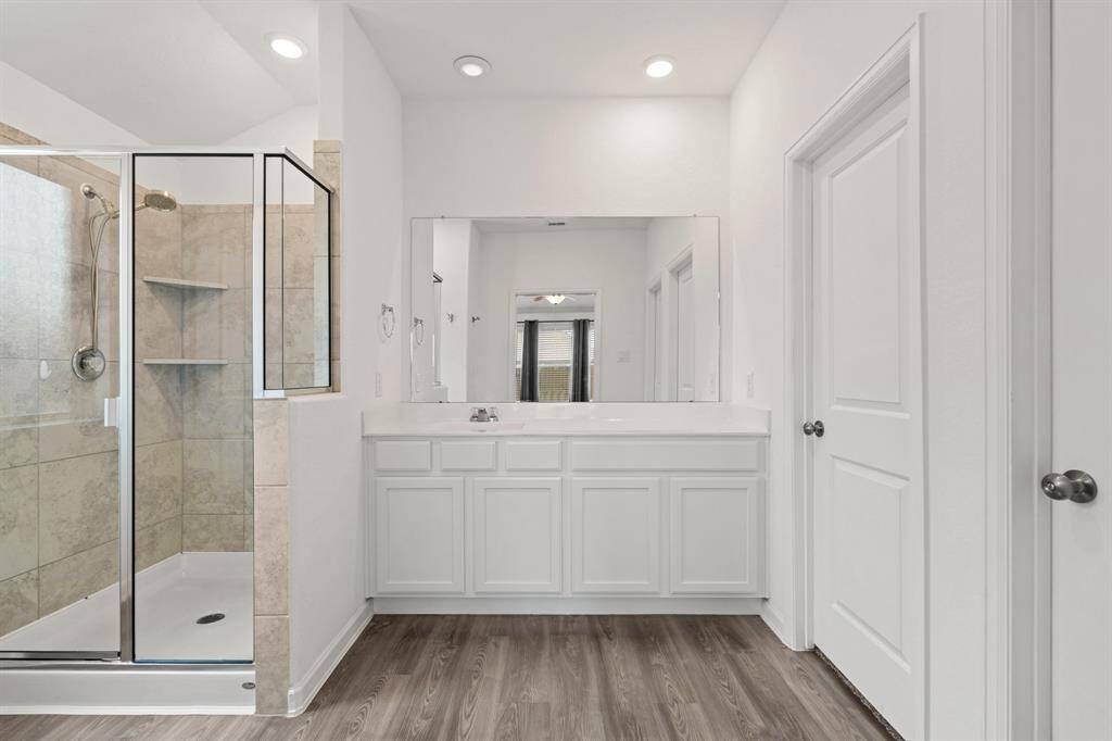 Primary bathroom with walk in shower and walk in closet.