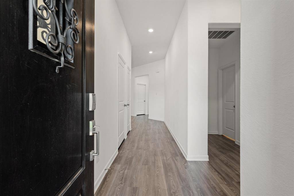 Long entry hallway, with secondary bedrooms to the right.