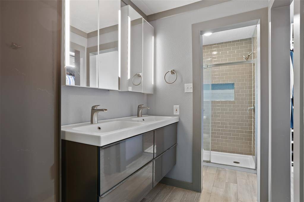 The primary bathroom is completely remodeled and features double sinks and a walk in shower.