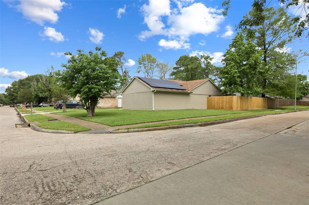 The house sits on an oversized corner lot with a spacious side yard.
