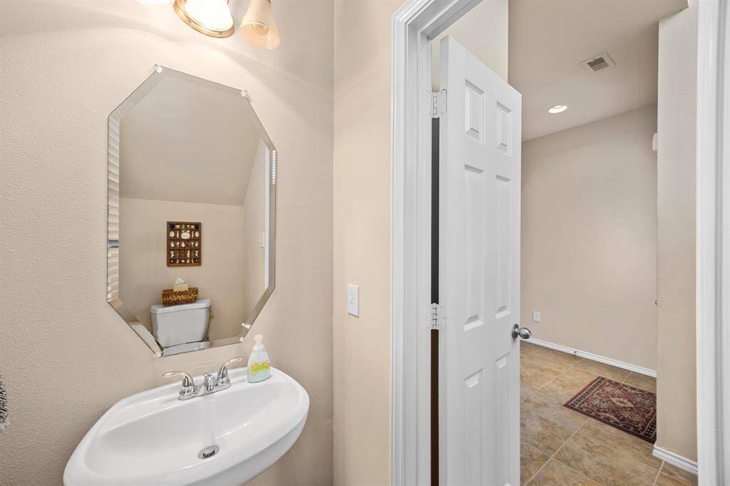 The half bath downstairs features a pedestal sink.