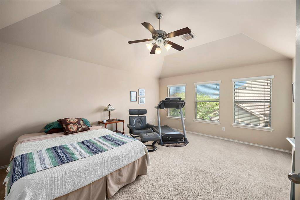 The spacious primary bedroom features a ceiling fan and three large windows!