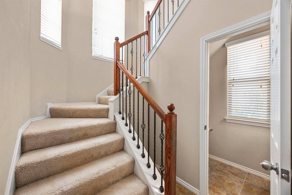 The staircase features large windows allowing for more natural light to penetrate the home.