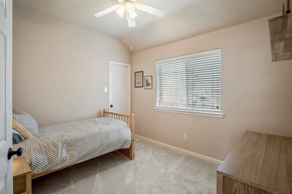 This secondary bedroom features brand new carpet and a spacious walk-in closet, offering plenty of room for storage and creating a comfortable space to relax or rest.