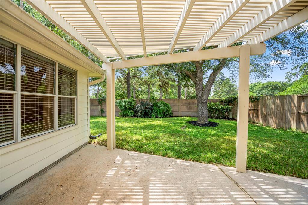 Stepping out onto the back porch, you'll be greeted by a pergola-style cover, offering a perfect space to relax, entertain, or enjoy the outdoors in comfort and style.