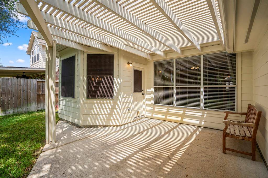 Looking back across the back porch towards the back door, you'll notice the solar screens on the bay windows surrounding the breakfast nook, helping to enhance energy efficiency while maintaining the home’s bright and airy feel.
