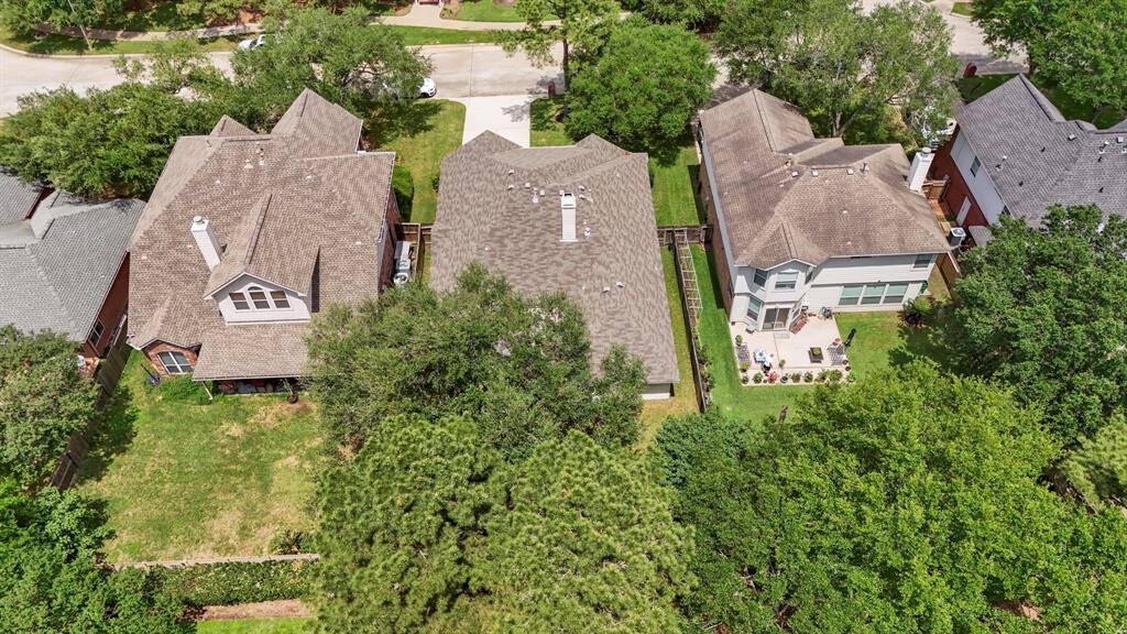 A view from above the backyard offers a full perspective of the home’s layout, highlighting the spacious yard, mature tree, and the privacy created by no rear neighbors. It’s the perfect spot to enjoy peaceful outdoor living.