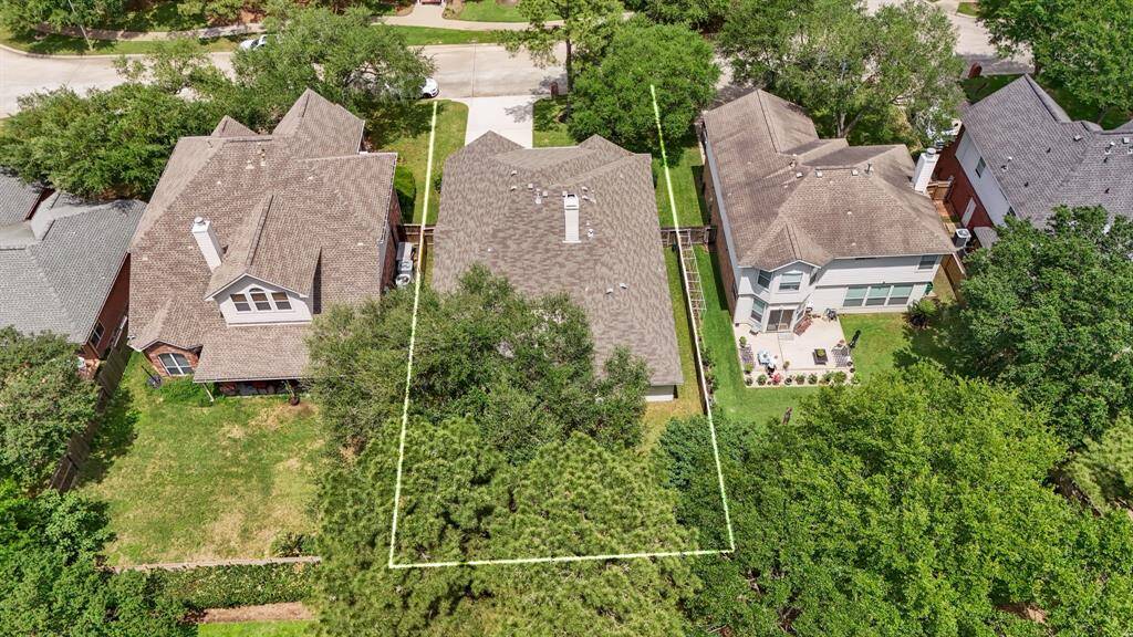 Aerial view of the home from above the backyard, showcasing the lot lines and highlighting the spacious yard, mature tree, and the privacy provided by no rear neighbors, offering a perfect canvas for outdoor enjoyment.
