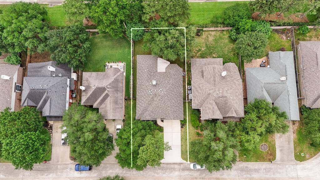 An aerial view taken from closer to the street in front of the home shows the lot lines, emphasizing the privacy of no neighbors behind and the spaciousness of the property, offering a serene and open setting.