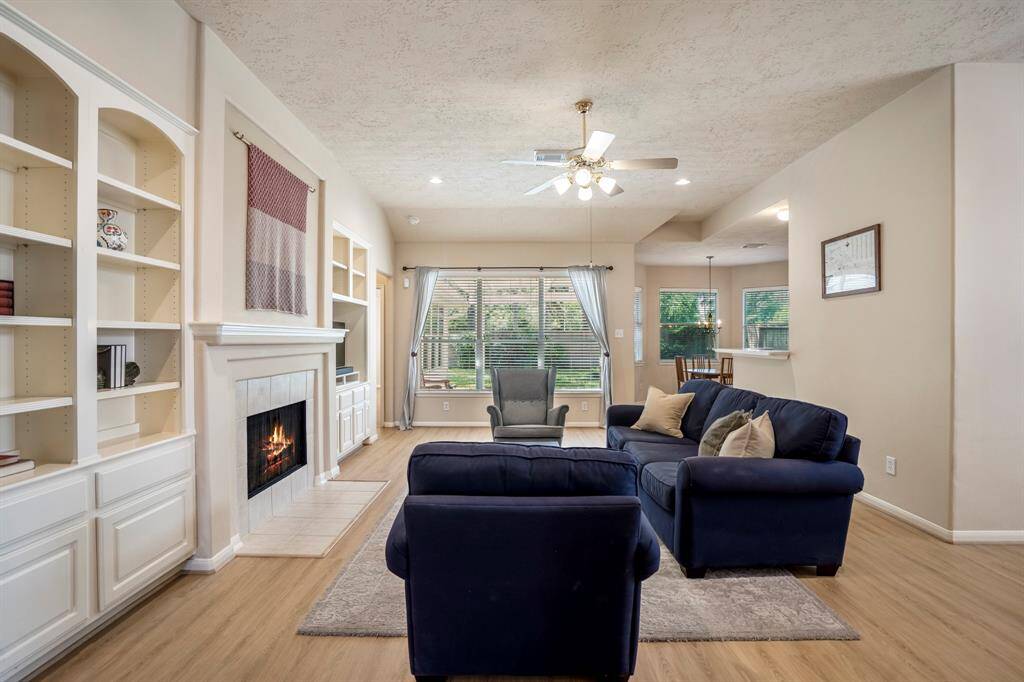 As we move into the living room, the fireplace with built-in shelving on either side takes center stage, complemented by beautiful trim work, rounded corners, and a recessed art niche above the mantel. The brand new vinyl plank flooring and abundance of natural light create a warm, inviting atmosphere. To the right, the formal dining room is just out of view, while at the rear of the home, the breakfast area with bay windows offers a bright, airy space. The kitchen is conveniently located between.