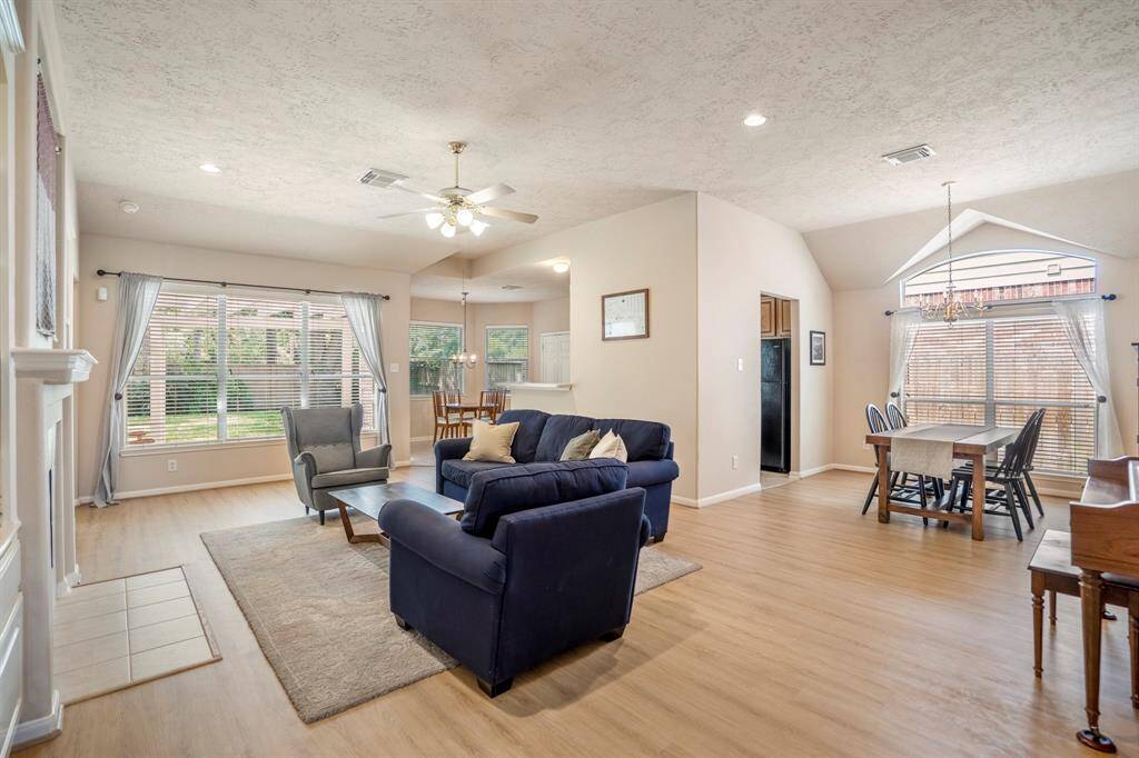 From this vantage point, the open layout and seamless flow of the living spaces become clear. In the forefront, the living room offers a cozy retreat, while to the right, the formal dining room provides an elegant setting for meals. To the left, the bright breakfast area with bay windows creates a welcoming spot to start your day, with the kitchen thoughtfully positioned between the two dining areas for easy access and convenience.