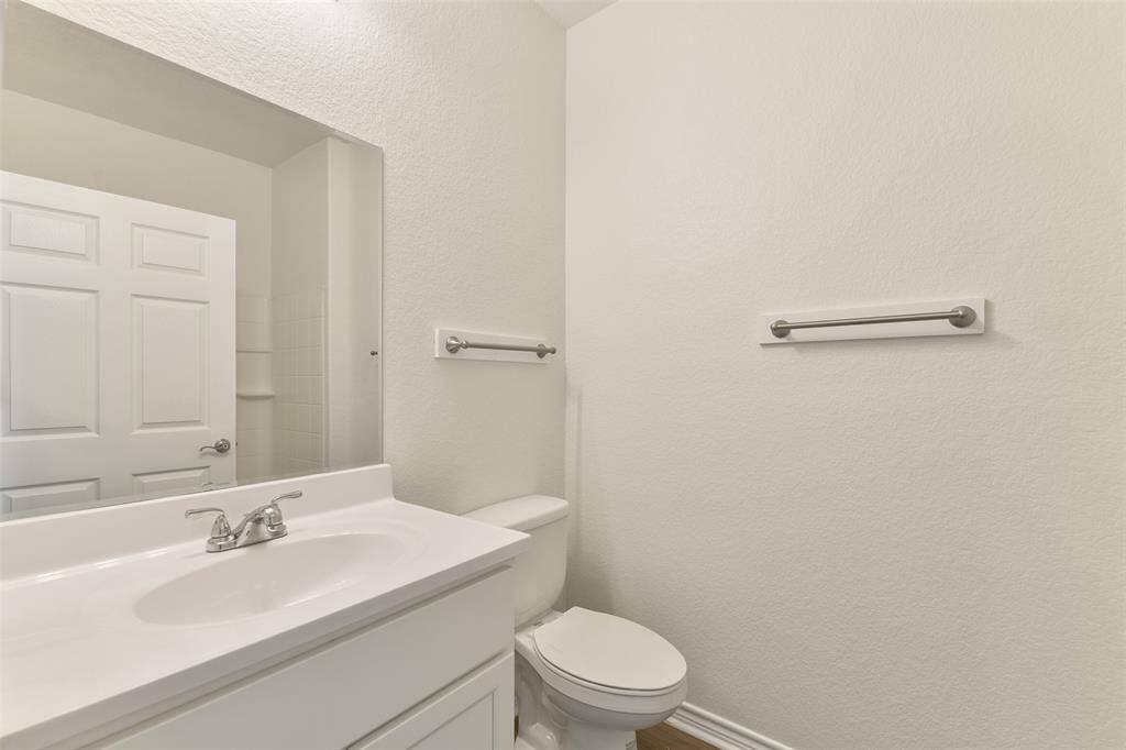 This bedroom services the secondary bedrooms with a clean, modern all-white vanity, a basin sink with a chrome faucet, neutral wall colors, and a combination bathtub and shower with a white tile surround.