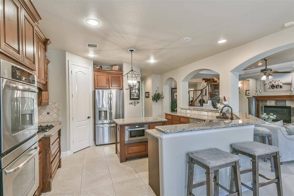 Bar height countertops all the way around the kitchen area. Beautiful archways to divide but not separate the open concept.