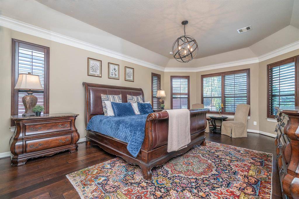 What a room! Can we call it a master retreat? Because THIS is a master retreat! Fabulous orb lighting, high ceiling & crown moulding, hardwood flooring and custom shutters can be found in this massive room. Views of the backyard pool area from these windows.