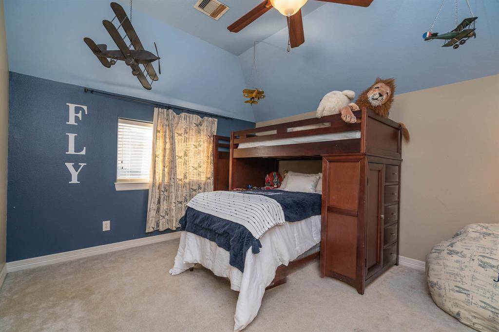 The first of 6 upstairs bedrooms with high ceilings, lighted ceiling fan, and a walk-in closet with custom cabinetry and drawers. Large window with 2 inch blinds.