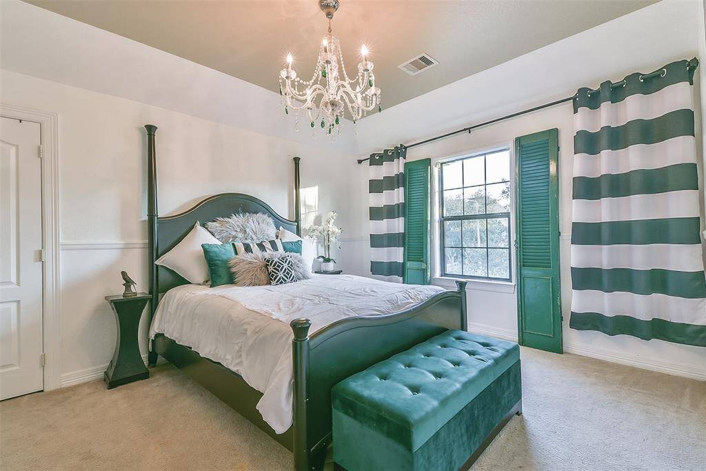 Room fit for a queen! Chandelier with custom green glass crystals. Antique french emerald green shutters can stay if desired. This room has a walk in closet and attached personal bathroom space. High ceilings and window facing the front of the home. See, room fit for a queen!