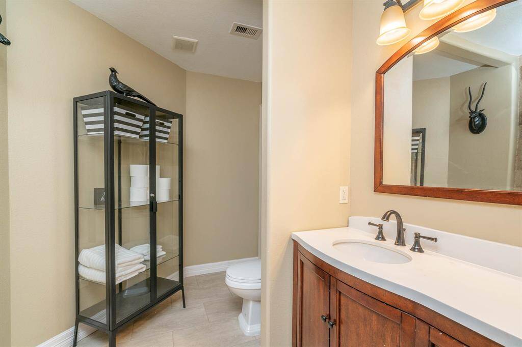 Bathroom attached to the chandelier bedroom with beautiful stone top vanity, oil rubbed bronze fixtures.