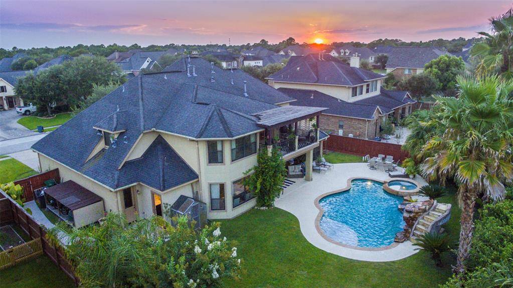 Aerial view of the home, spacious backyard, fabulous pool area, tropical landscaping. Located in the Forest of Friendswood custom homes section, Northfield Estates. Cul de sac lot!