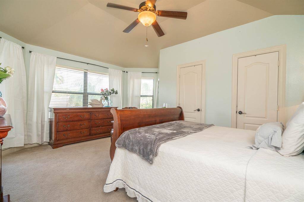 Another view of the 6th upstairs bedroom bathed in natural light from all the windows and glass door leading to the balcony. Double doors on the right are closets. Nice high ceilings!