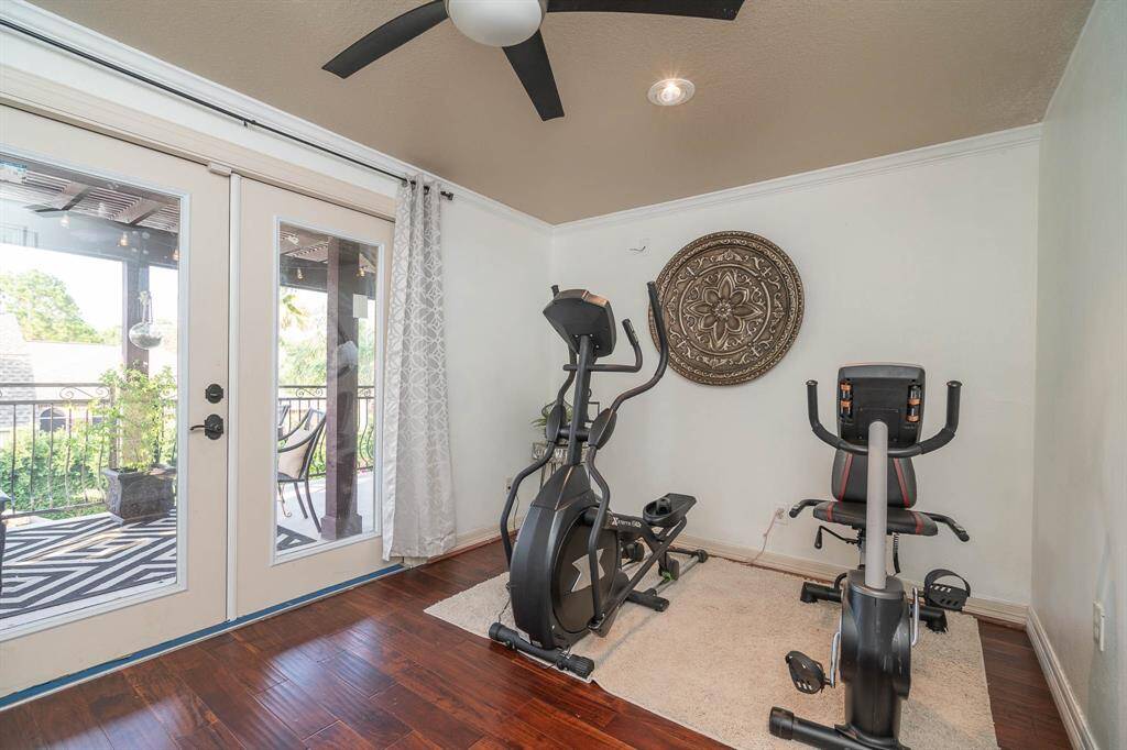 Fitness area with solid wood flooring, views and access onto the balcony with glass french doors. Recessed lighting, crown moulding, wired for surround sound! This is half of the upstairs game room.