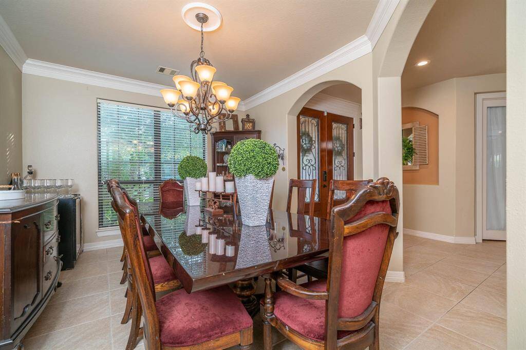 Formal dining room framed with open archways. This space currently has a table that can seat 10-12 people! Crown moulding and chandelier accent this space nicely. Large picture window with views to the front of the home dressed in 2" wood blinds.