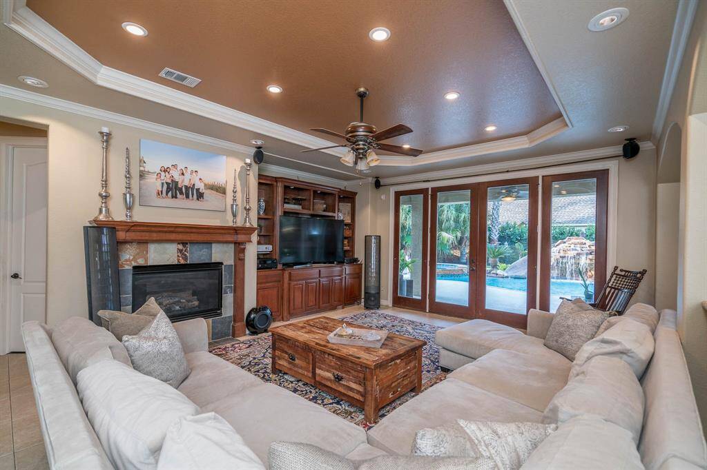 Wall of windows!!! Double doors lead to the back patio and pool area. Gas log fireplace, and built in entertainment area with plenty of cabinets and shelving. Recessed lighting, surround sound, crown moulding and lighted ceiling fan compliment the space well.