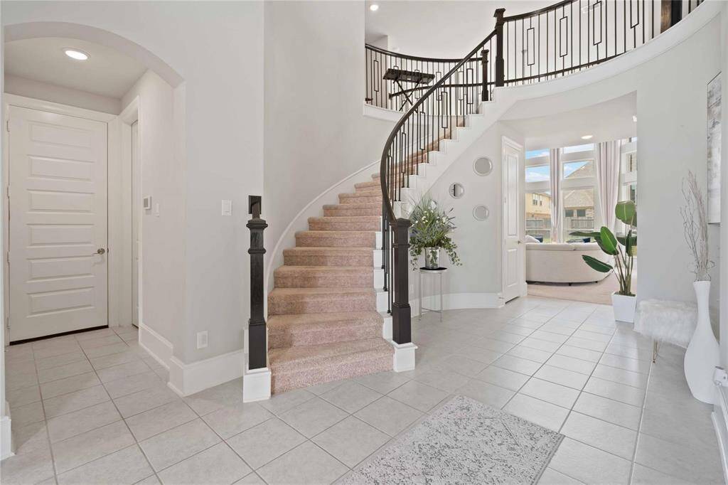 stairs coming down to foyer at entrance of home