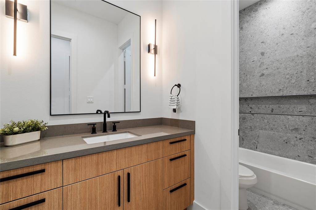 Contemporary sconces and an expansive mirror set the tone for a space where morning prep feels like a calm ritual, not a rush.