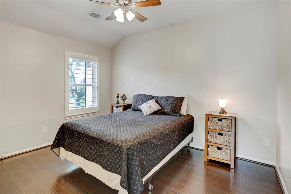 This bedroom features lovely flooring, neutral walls, and a ceiling fan.