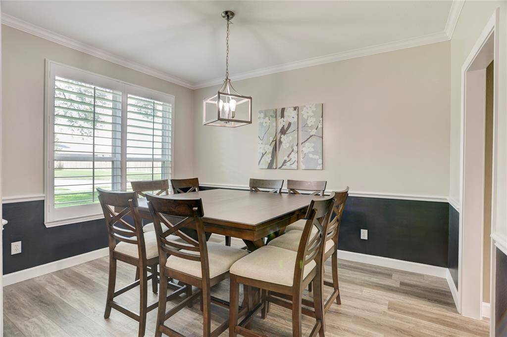 Bright dining area with large windows, modern light fixture, and neutral tones. Ideal for gatherings.