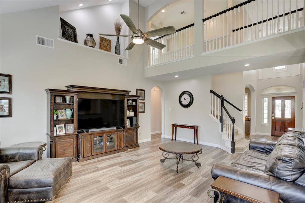 Spacious living room with high ceilings! The area is well-lit with natural light from the entryway, enhancing its welcoming ambiance.