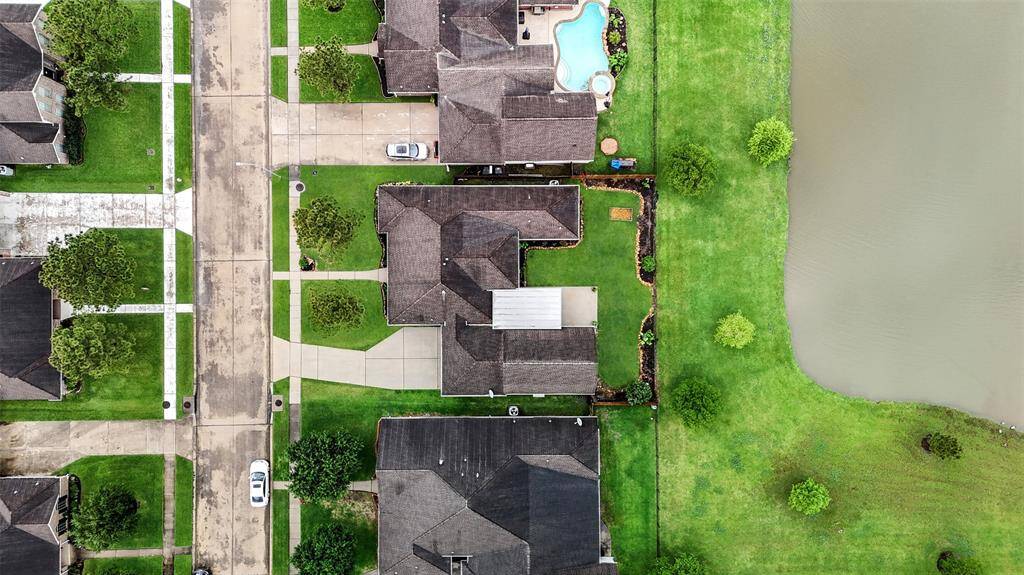 Cervelle Home with 4-car garage, porte-cochere, and bonus room above—backing to the lake with a pergola-covered patio and spacious backyard.