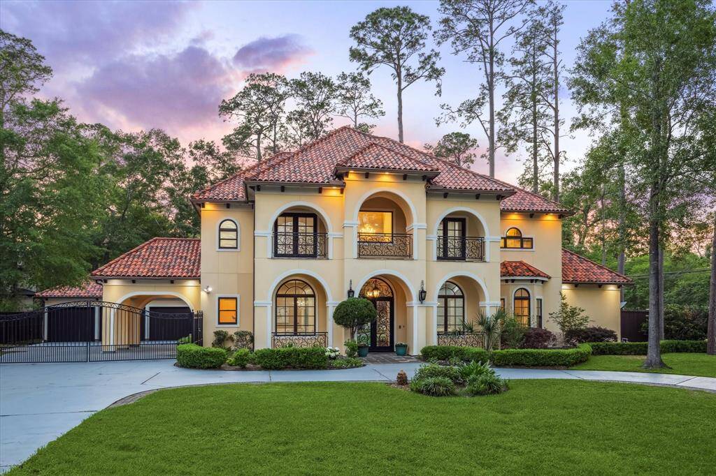 Elegant Mediterranean façade with arched balconies, terracotta roof tiles, and lush landscaping welcomes you home in timeless style.